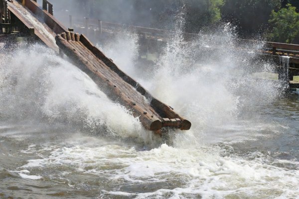 Log flume vessel plunging into a run-out trough with a massive white water spray